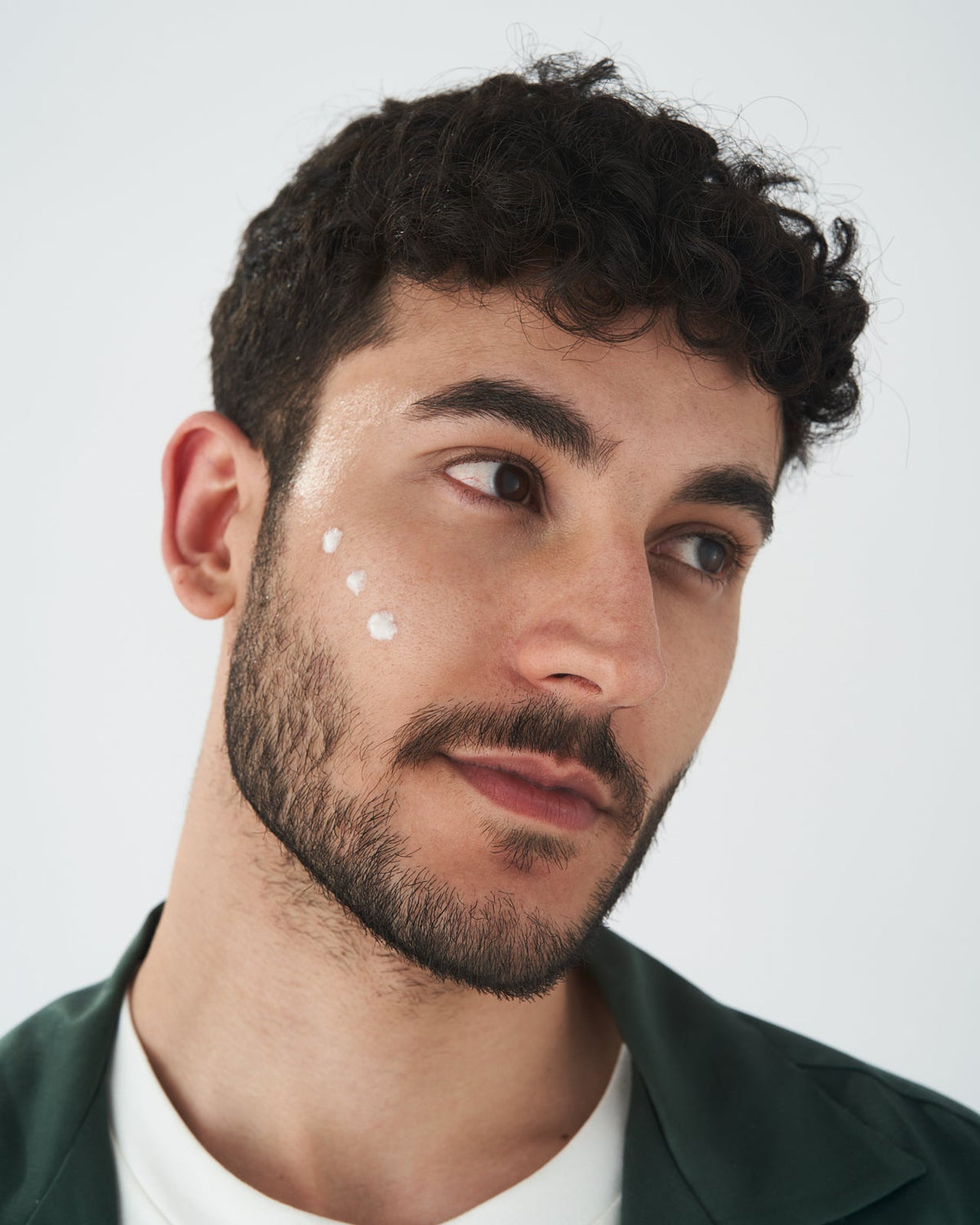 Persona applica una crema viso durante la routine VOVEES