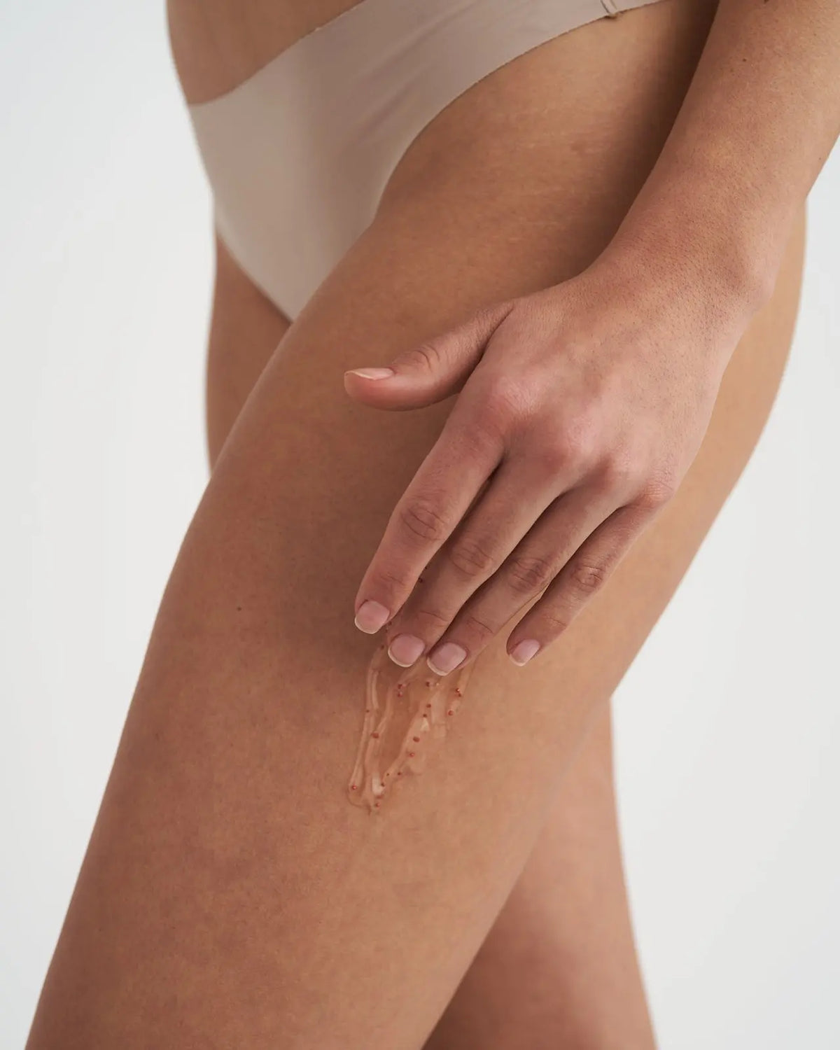 Texture del gel corpo VOVEES LipoGel con sfere di caffeina applicata sulla coscia.