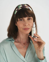 Donna tiene il flacone del gel contorno occhi VOVEES Theia.