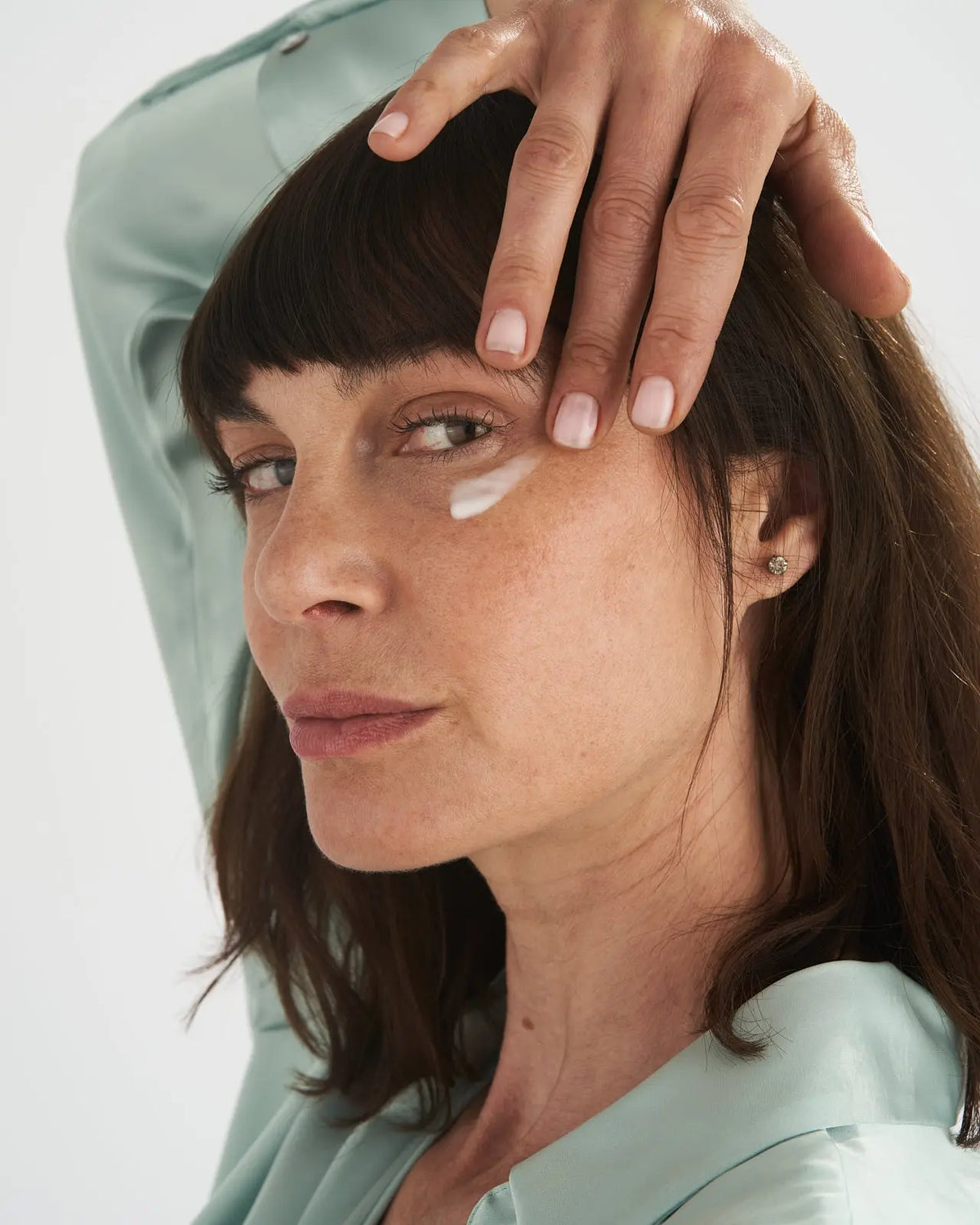 Donna applica la crema viso VOVEES BLD9 nella zona dello zigomo.